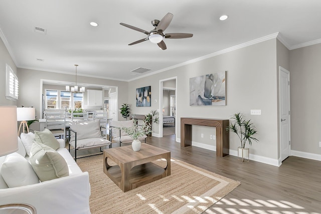 living room with crown molding, wood-type flooring, and ceiling fan with notable chandelier