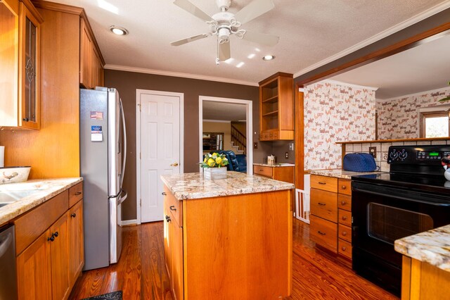 kitchen featuring ornamental molding, brown cabinetry, appliances with stainless steel finishes, and a kitchen island