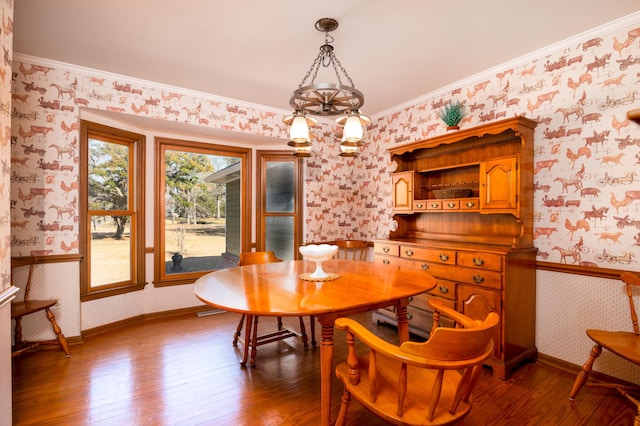 dining area featuring a wainscoted wall, hardwood / wood-style flooring, and wallpapered walls