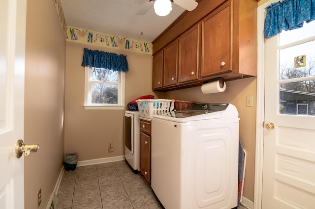 washroom featuring baseboards, light tile patterned flooring, cabinet space, a textured ceiling, and washer and dryer