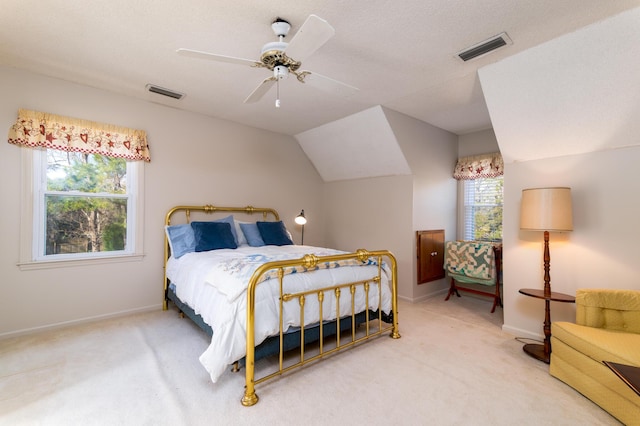 carpeted bedroom with a ceiling fan, lofted ceiling, baseboards, and visible vents