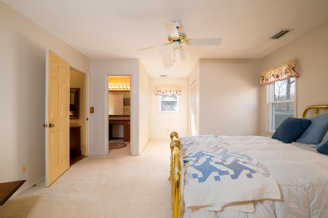 bedroom featuring visible vents, baseboards, light carpet, a textured ceiling, and a ceiling fan