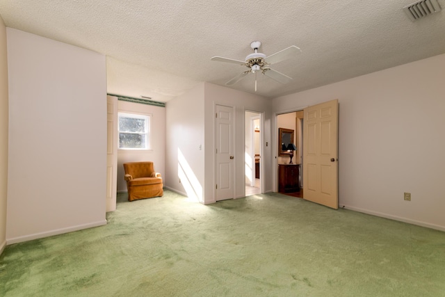 unfurnished bedroom with visible vents, ceiling fan, baseboards, carpet, and a textured ceiling