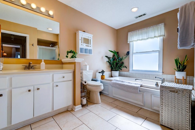 bathroom featuring tile patterned flooring, visible vents, toilet, a bath, and vanity