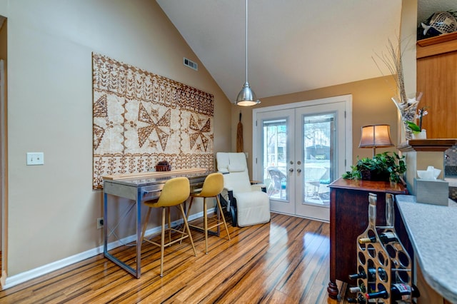 office area featuring visible vents, baseboards, lofted ceiling, french doors, and wood finished floors