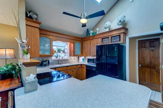 kitchen featuring black appliances, a ceiling fan, a sink, brown cabinetry, and glass insert cabinets