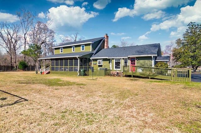 back of house with a lawn, a chimney, and a sunroom