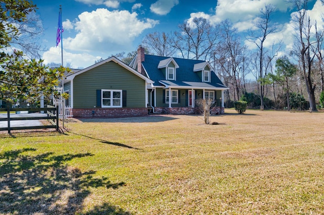 cape cod house featuring a chimney, a front lawn, and fence