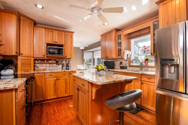 kitchen featuring dark wood finished floors, stainless steel appliances, ceiling fan, and a sink