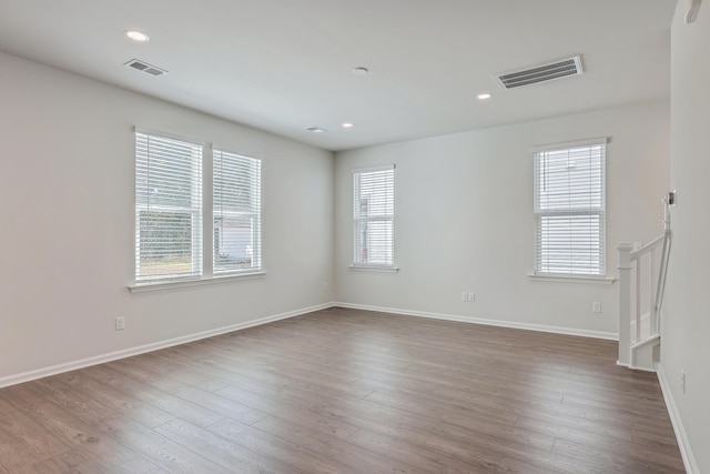 empty room with hardwood / wood-style flooring and a healthy amount of sunlight