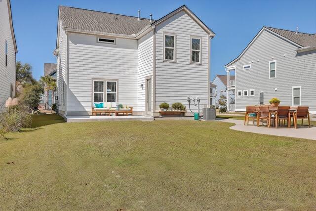 back of property with a yard and a patio area