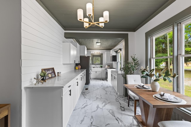 285 Roosevelt Dr, Saint Stephen, SC 29479 - kitchen featuring light marble finish floors, freestanding refrigerator, a chandelier, white cabinets, and ornamental molding