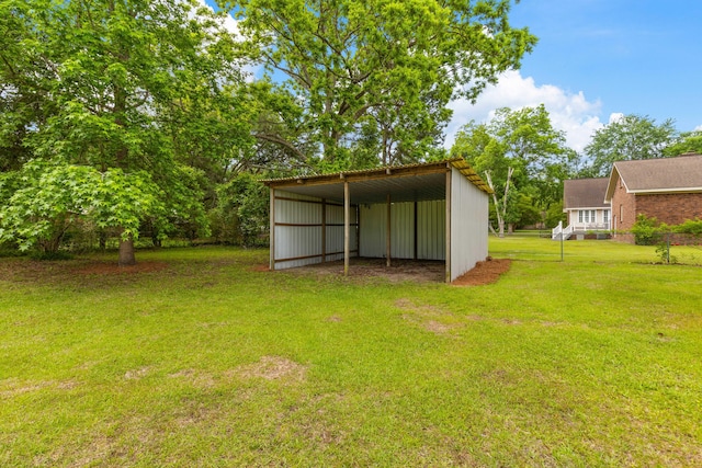 285 Roosevelt Dr, Saint Stephen, SC 29479 - view of grassy yard featuring a pole building, a detached carport, an outdoor structure, and driveway