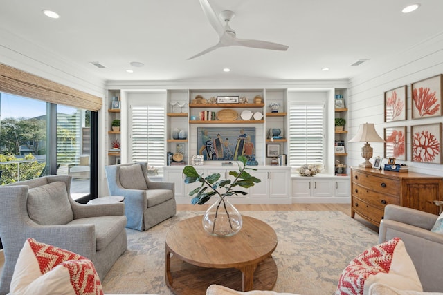 living room featuring light hardwood / wood-style floors, wood walls, and ceiling fan