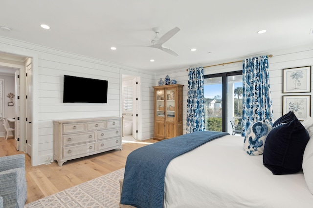 bedroom featuring ceiling fan, access to exterior, light hardwood / wood-style floors, and wooden walls