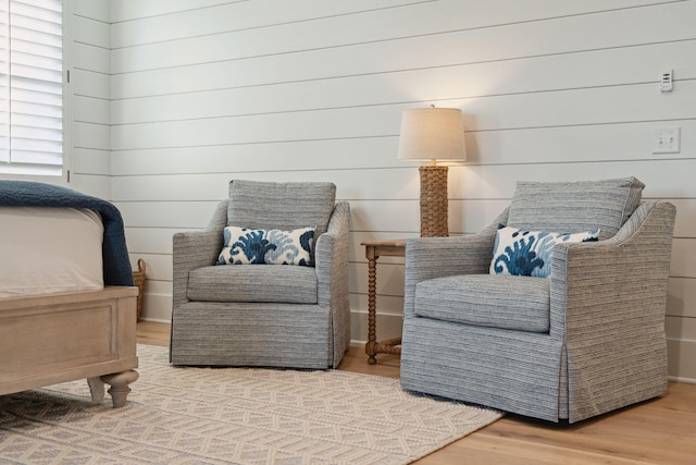 living area featuring wood walls and hardwood / wood-style floors