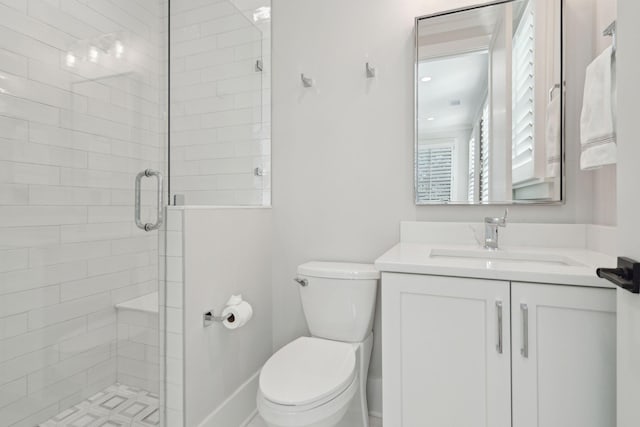 bathroom featuring a shower with door, toilet, and vanity