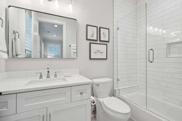 full bathroom featuring toilet, vanity, and shower / bath combination with glass door