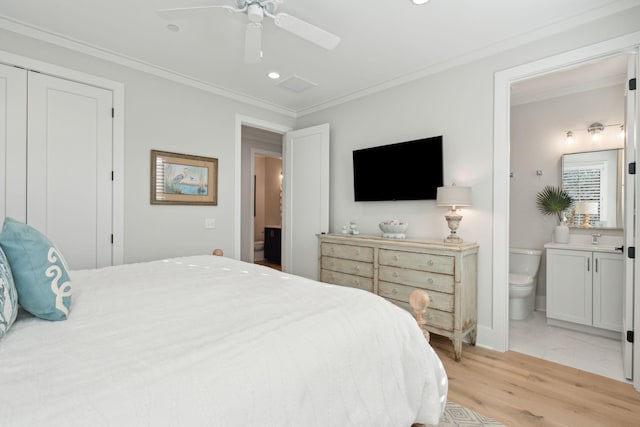 bedroom featuring ceiling fan, crown molding, light hardwood / wood-style flooring, and ensuite bath