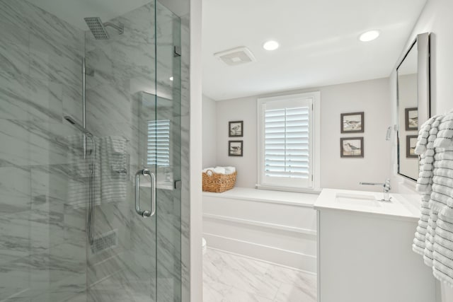 bathroom with a shower with shower door and vanity