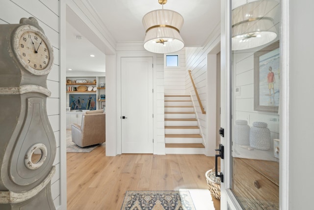 entryway featuring light hardwood / wood-style floors and crown molding