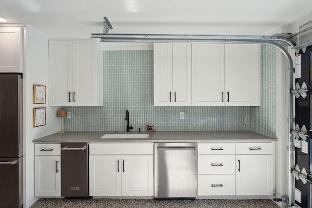 kitchen with appliances with stainless steel finishes, backsplash, white cabinets, and sink