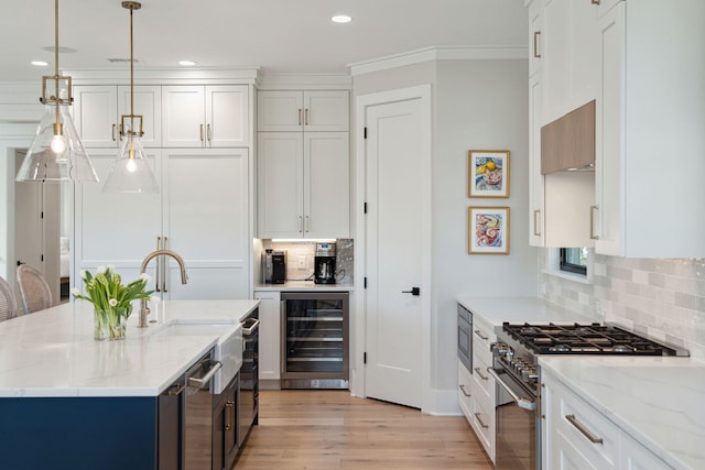 kitchen with wine cooler, light stone countertops, stainless steel appliances, and white cabinetry