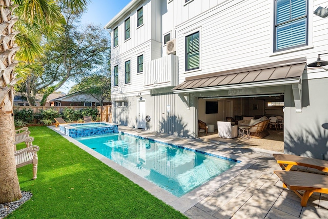 rear view of property featuring a patio area, a yard, and a swimming pool with hot tub