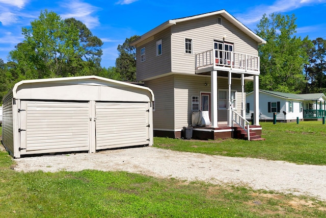 back of house with a lawn, a balcony, and a storage shed