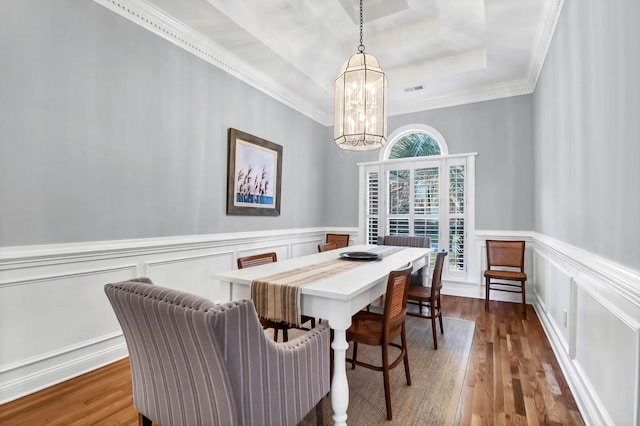 2707 Waterpointe Cir, Mount Pleasant, SC 29466 - dining room with a chandelier, a raised ceiling, a decorative wall, wood finished floors, and ornamental molding