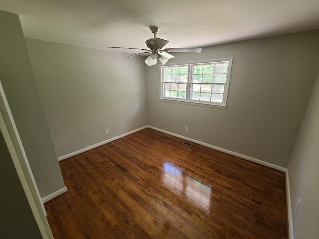 spare room with dark hardwood / wood-style flooring and ceiling fan