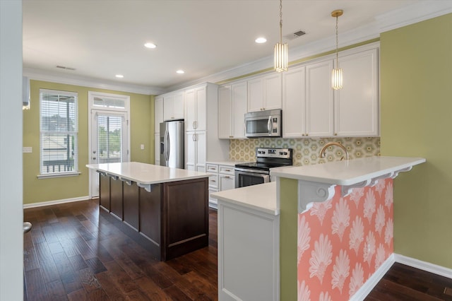 1533 Bluewater Way, Charleston, SC 29414 - kitchen with appliances with stainless steel finishes, dark wood finished floors, a breakfast bar area, crown molding, and white cabinets