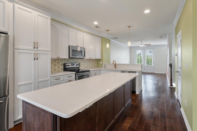 1533 Bluewater Way, Charleston, SC 29414 - kitchen with stainless steel appliances, a peninsula, ornamental molding, dark wood-type flooring, and a kitchen island