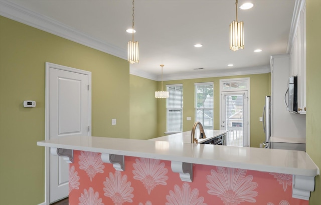 1533 Bluewater Way, Charleston, SC 29414 - kitchen featuring appliances with stainless steel finishes, a kitchen breakfast bar, ornamental molding, light countertops, and white cabinets