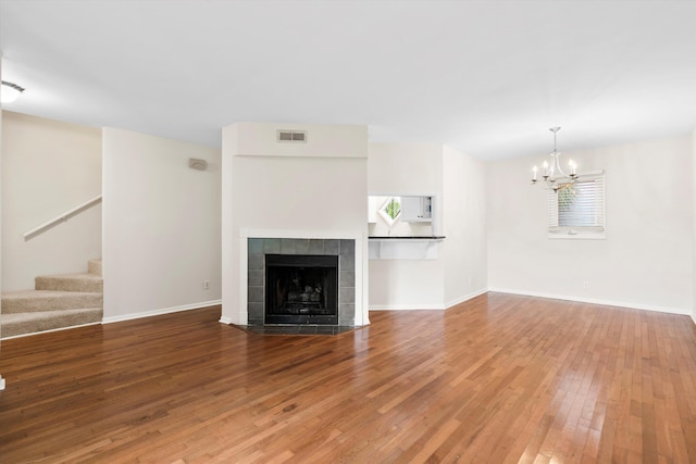 22 Ogier St, Charleston, SC 29403 - unfurnished living room with stairs, hardwood / wood-style flooring, a chandelier, and a tiled fireplace