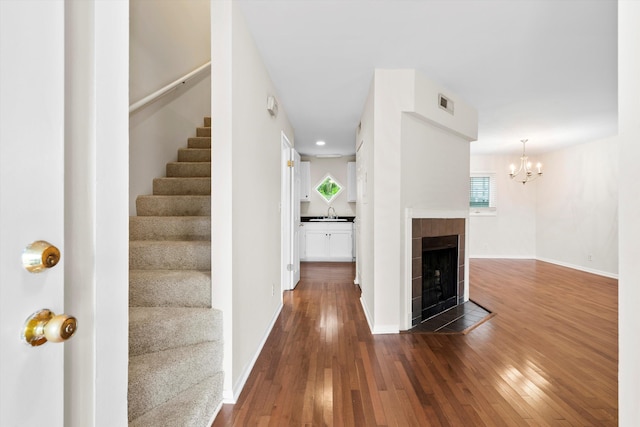 22 Ogier St, Charleston, SC 29403 - stairway with wood-type flooring, a chandelier, and a fireplace