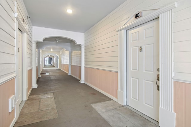 corridor featuring wooden walls