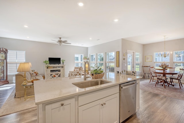 kitchen with dishwasher, hanging light fixtures, sink, white cabinets, and light hardwood / wood-style floors