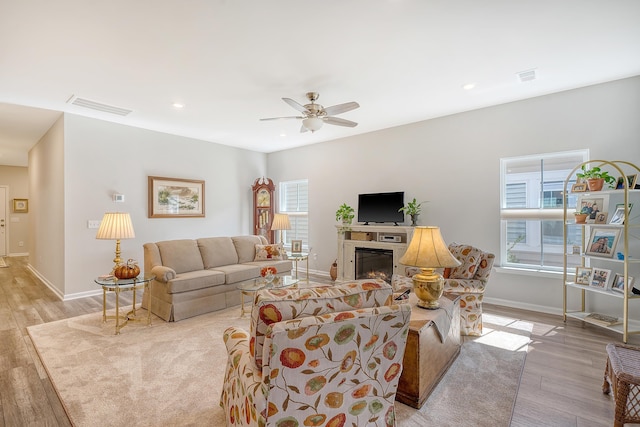 living room featuring a wealth of natural light, light hardwood / wood-style floors, and ceiling fan