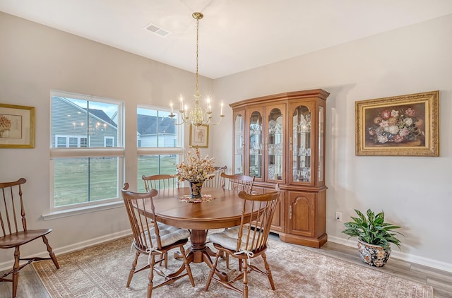 dining space featuring a chandelier and light wood-type flooring