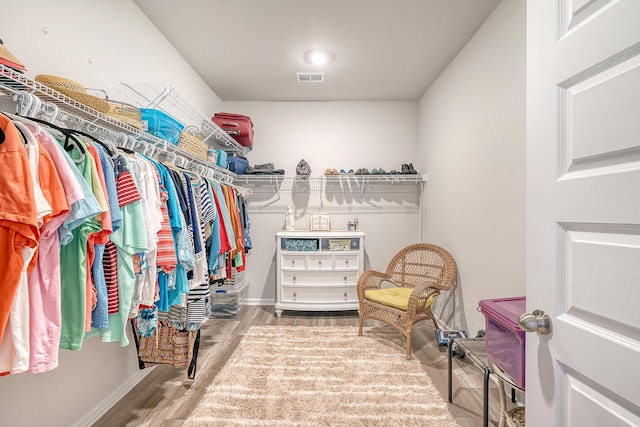 walk in closet with light hardwood / wood-style flooring