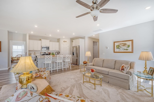 living room with light wood-type flooring and ceiling fan