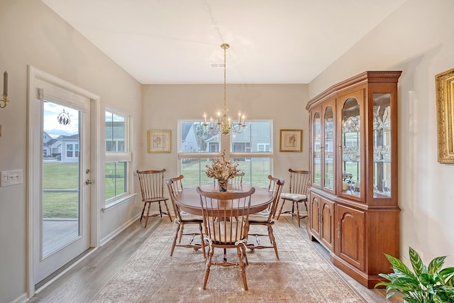 dining area featuring light hardwood / wood-style flooring and a notable chandelier