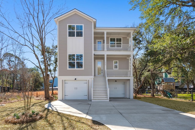 beach home with concrete driveway, a playground, a balcony, and an attached garage