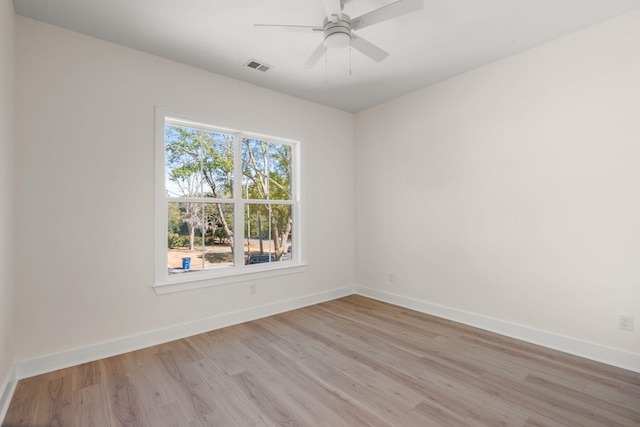 empty room with baseboards, visible vents, ceiling fan, and light wood finished floors