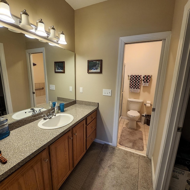 bathroom with toilet, tile patterned flooring, and vanity