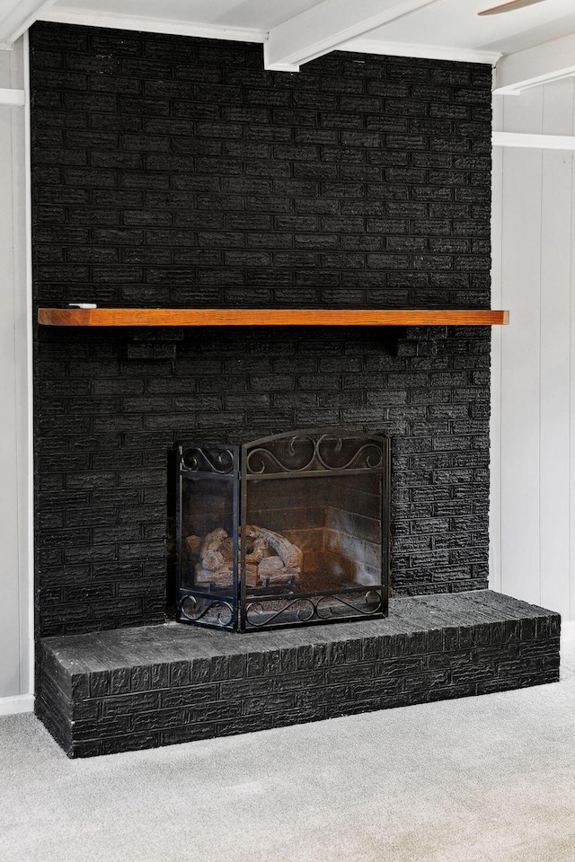 room details with beamed ceiling, a fireplace, and carpet floors