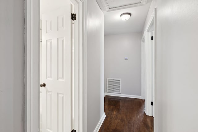 hall featuring visible vents, baseboards, and wood finished floors