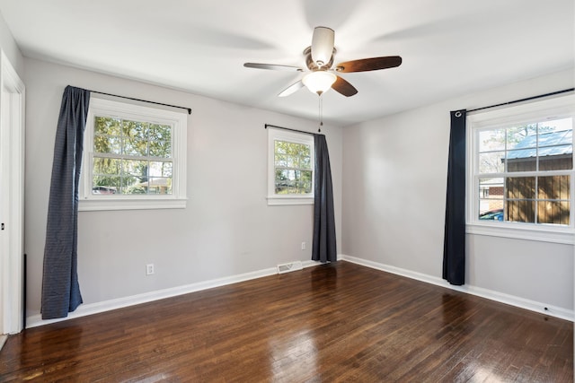 spare room with visible vents, baseboards, ceiling fan, and hardwood / wood-style flooring