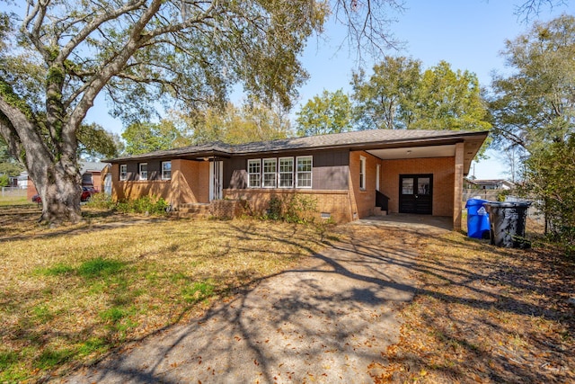 ranch-style house featuring a carport, brick siding, driveway, and crawl space